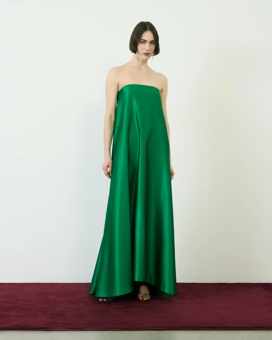 Woman standing in an emerald green strapless gown